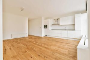a-spacious-empty-room-with-a-corner-kitchen-on-parquet-floors-1-1.jpg