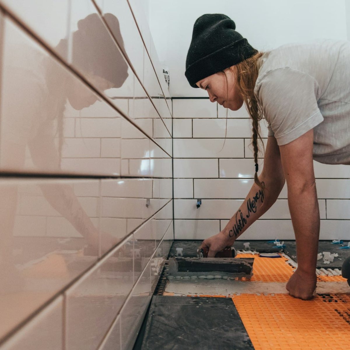 masonry-with-white-subway-tiles-and-black-slate-floor-tiles-and-woman-worker-diy-bathroom-remodel.jpg