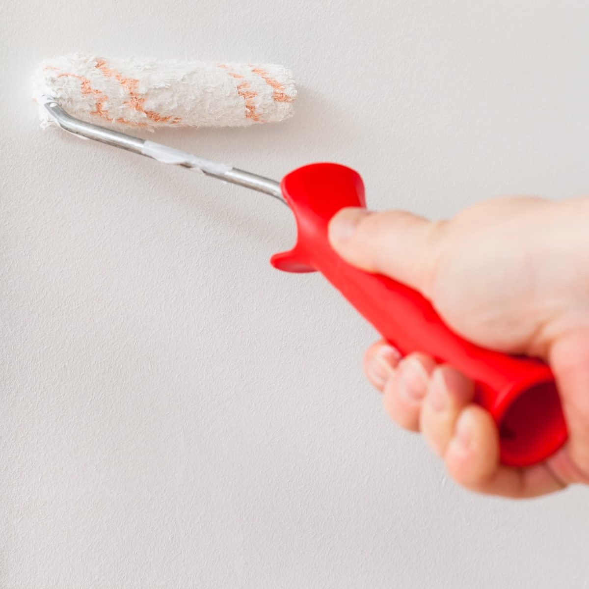 Maler Stade 4 painter-paints-wall-with-paint-roller.jpg