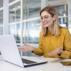woman-in-yellow-blouse-having-a-video-conference-call-at-modern-office.jpg